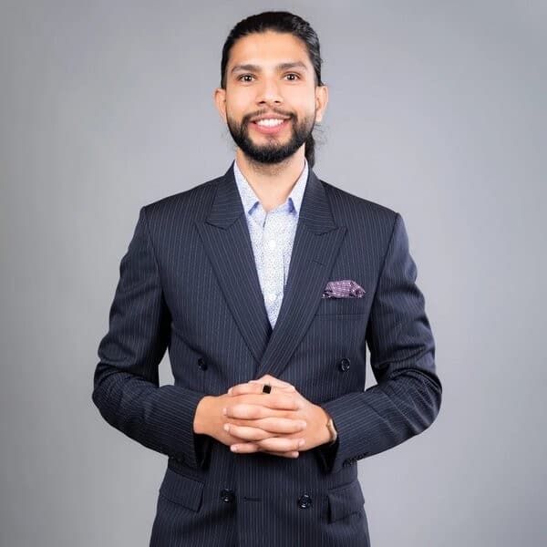 Portrait of Samir Adhikari in a navy pinstripe suit